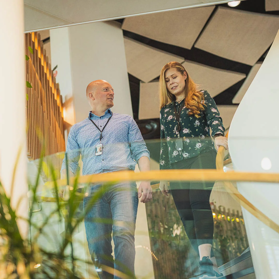 A man and a woman walk down the stairs.